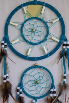Blue Dreamcatcher with feathers and beads isolated on a white background.