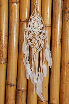 Beige crochet doily dream catcher close up on gray textured background. Texture of concrete, wodden background.