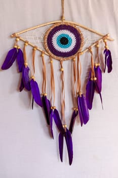 divine eye of providence dreamcatcher with colored feathers on a white background.