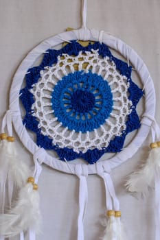 Blue Dreamcatcher with feathers and beads isolated on a white background.