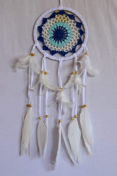 Blue Dreamcatcher with feathers and beads isolated on a white background.