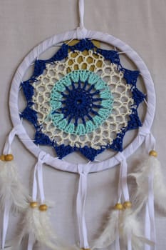 Blue Dreamcatcher with feathers and beads isolated on a white background.