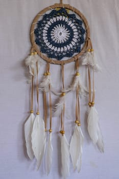 Blue Dreamcatcher with feathers and beads isolated on a white background.