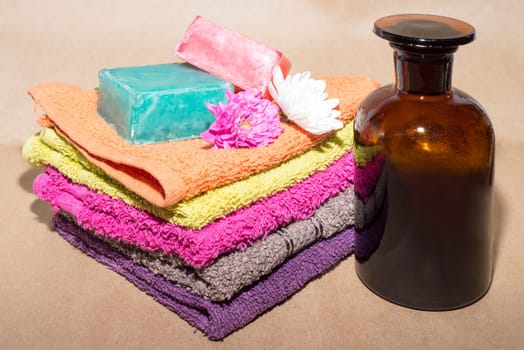 soap bar on top of facecloths off various shades with flowers and bottle