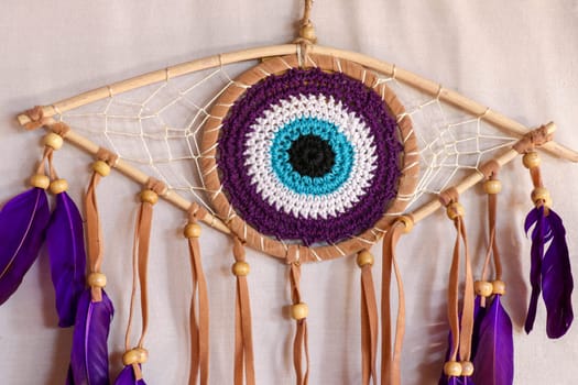 divine eye of providence dreamcatcher with colored feathers on a white background.