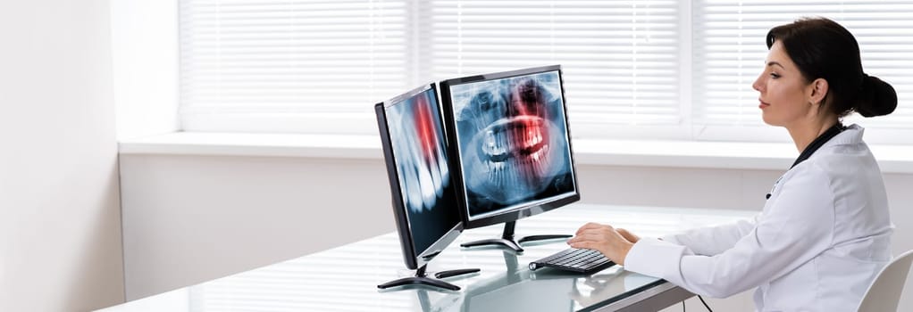 Dentist Doctor Looking At Teeth Xray On Computer