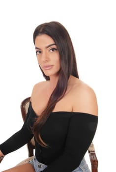 A gorgeous young woman sitting in a old armchair for a portrait, in.shorts and black top, isolated for white background.