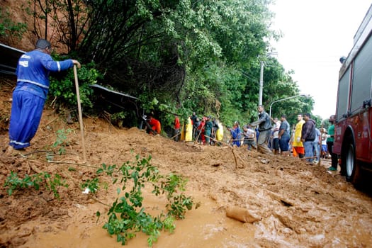 salvador, bahia / brazil - april 9, 2015: members of the fire department and volunteer people are seen during excavation of land that slid from a slope in the city of Salvador. the group seeks victims in the middle of the earth....