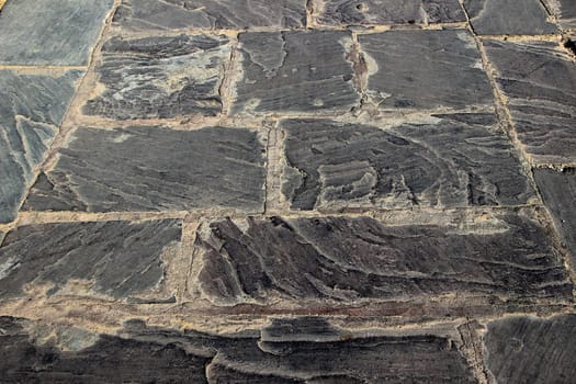 Closer view of granular, polished, black stone flooring in old and chipped off condition