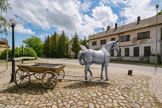 Jekabpils, Latvia - June 16, 2020: Sculpture "Horse with a carriage"" (author - Gaits Burvis) on the historic Wednesday market place in Jekabpils, Latvia"