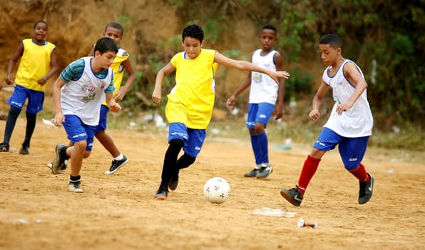 salvador, bahia / brazil - december 21, 2015: young people are seen playing sports on the ground football field in the Fazenda Grande neighborhood in the city of Salvador.