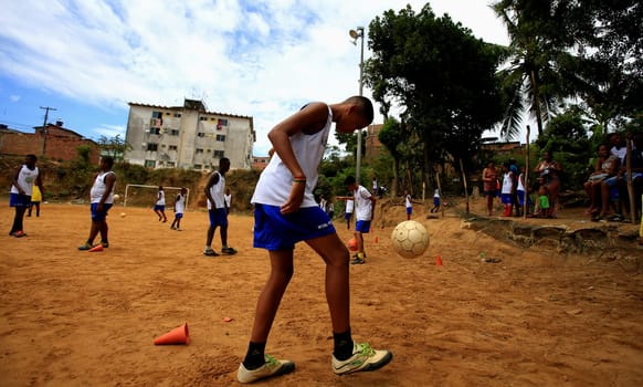 salvador, bahia / brazil - december 21, 2015: young people are seen playing sports on the ground football field in the Fazenda Grande neighborhood in the city of Salvador.