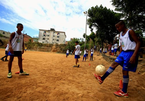 salvador, bahia / brazil - december 21, 2015: young people are seen playing sports on the ground football field in the Fazenda Grande neighborhood in the city of Salvador.