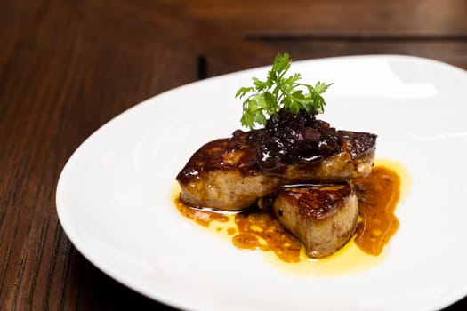 Grilled Foie gras, grilled duck and goose live poultry, with plum savory sauce. Gourmet internationl cuisine recipe using for buffet food and drink concept.
