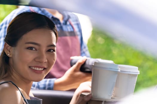 Asian woman customer make mobile payment contactless technology to waiter in drive thru food service while pickup coffee and bakery. Drive through is more  popular after coronavirus covid-19 pandemic.