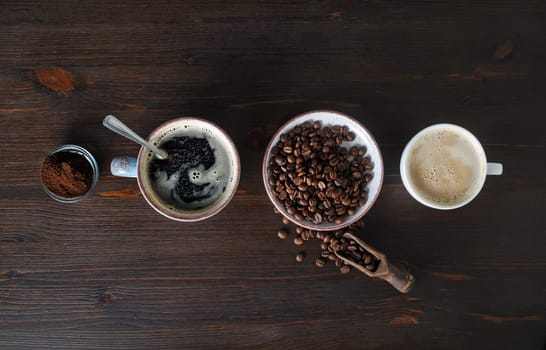 Espresso, coffee cup, coffee beans and ground powder on wood table background. Top view. Flat lay.