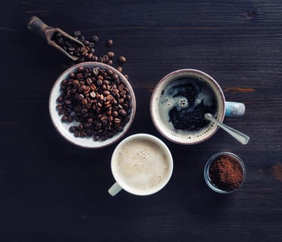 Photo of coffee cups, roasted coffee beans and ground powder on wooden table background. Top view. Flat lay.
