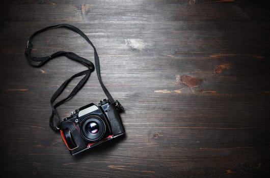 Black vintage camera on wooden background. Copy space for your text. Top view. Flat lay.