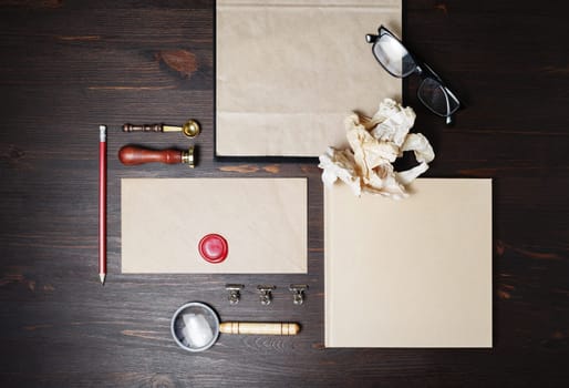Photo of blank kraft stationery set on wooden background. Corporate identity mock up for placing your design. Flat lay.