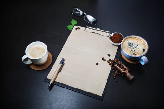 Blank stationery and coffee on black table background. Branding mock-up.