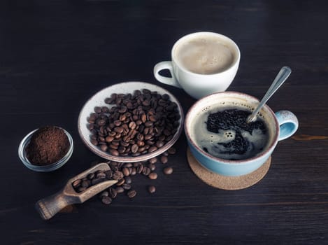 Still life with coffee. Photo of coffee cup, roasted coffee beans and ground powder on vintage wooden background.
