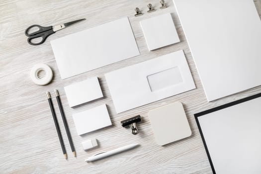 Blank stationery template on light wood table background. Mock-up for branding identity. For design presentations and portfolios. Flat lay.