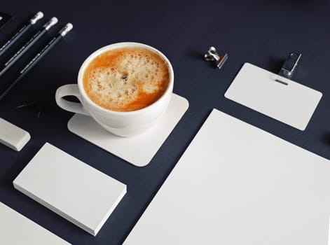 Blank corporate identity. Stationery set and coffee cup on black paper background. Branding mockup.
