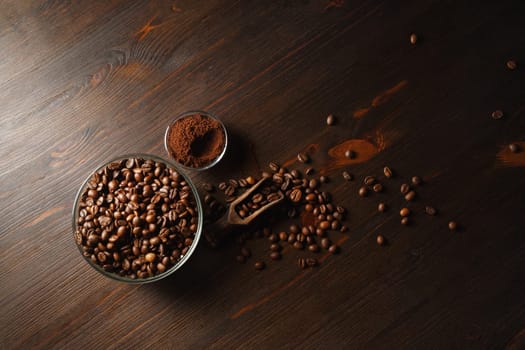 Coffee beans and ground powder on wooden background. Top view. Flat lay.