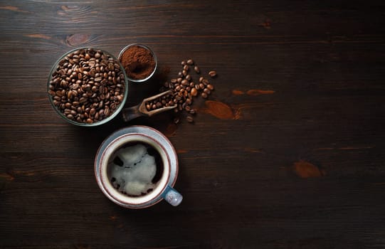 Vintage coffee background with space for text. Still life with cups of coffee, coffee beans and ground powder on wood table background. Flat lay.