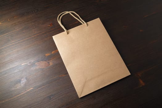 Blank vintage paper bag on wood table background. Recyclable package. Template ready for your design.