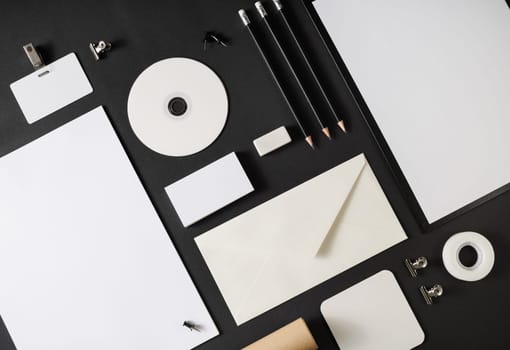 Blank corporate stationery set on black paper background. Template for branding design. Branding mock up. Top view. Flat lay.