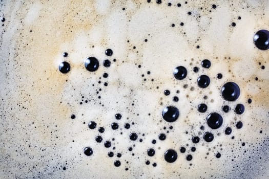Coffee foam with bubbles background. Close-up coffee texture. Top view. Flat lay.