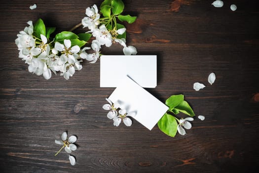 Photo of blank business cards and flowers on wooden background. Template for ID. Flat lay.