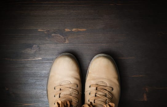 Shoes for travel. Travel boots on brown wood floor background. Copy space for your text. Flat lay.