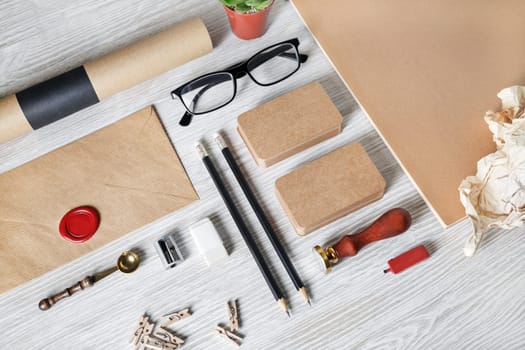 Blank kraft stationery template on light wooden background. Branding mock up for designers portfolios.