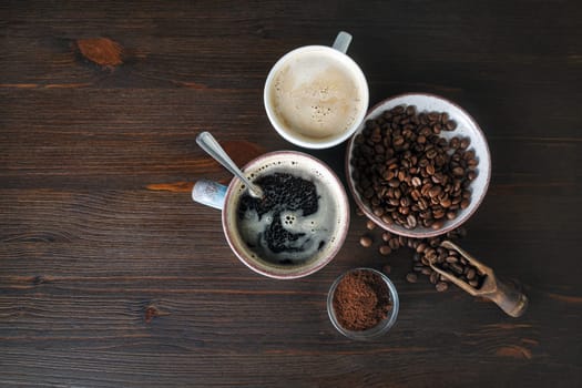 Coffee on wooden table background. Coffee cups, roasted coffee beans and ground powder. Flat lay.