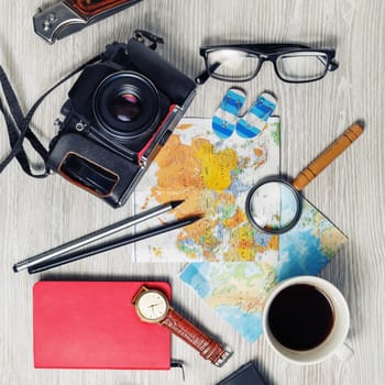Vintage tourist devices on light wood table background. Preparation for travel. Top view. Flat lay.