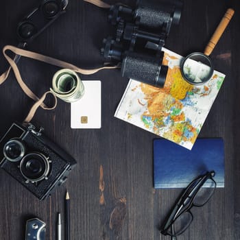 Planning vacation trip with map on vintage wood table background. Travel or vacation concept. Top view. Flat lay.