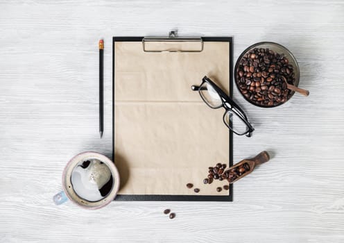 Blank retro stationery set and coffee on light wood table background. Branding mock-up. Flat lay.