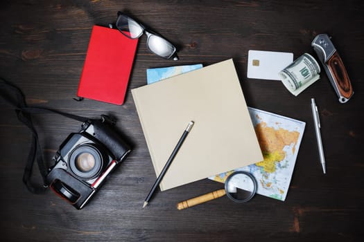 Photo of essential travel accessories on wooden background. Vacation items. Outfit of traveler. Top view. Flat lay.