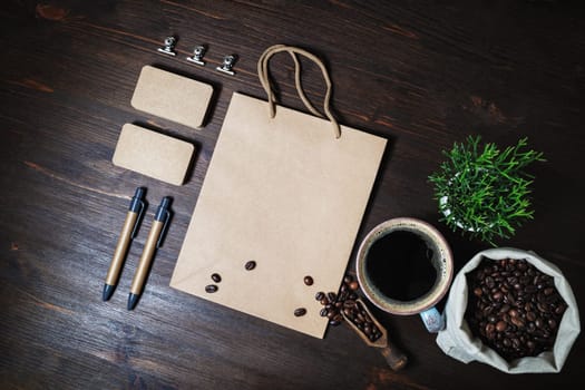 Vintage kraft stationery set and coffee on wood kitchen table background. Flat lay.