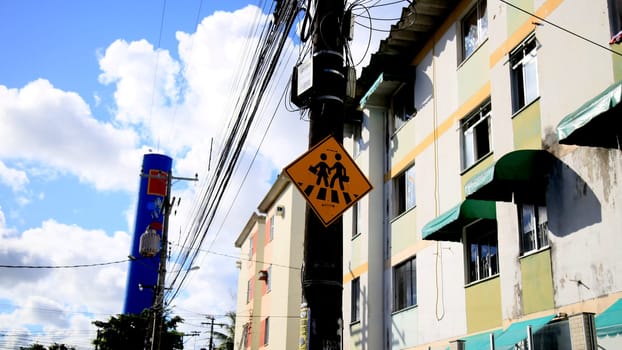 salvador, bahia / brazil - july 4, 2020: traffic signs indicate pedestrian crossing, seen on a pole connected to the electricity grid in the Cabula neighborhood, in the city of Salvador....