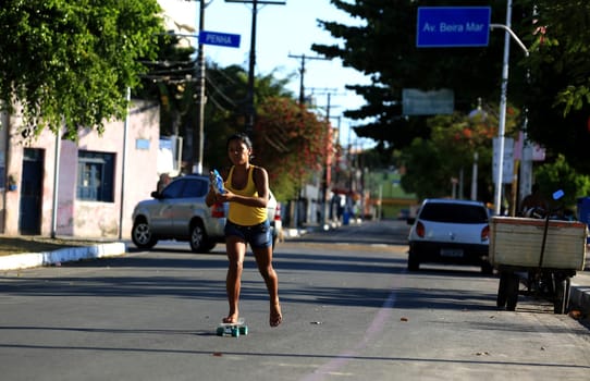 salvador, bahia / brazil - december 2, 2015: person walking sm skete on bike path on Beira Mar avenue in Ribeira neighborhood in the city of Salvador....