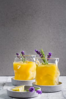 Summer orange and lemon cocktail with fresh lavender and rosemary. Summer lemonade with herbs.