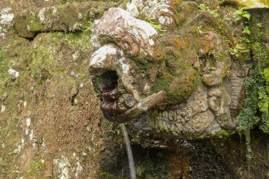 Gargoyles with holy water in the complex of royal tombs of the Udayan dynasty. Ancient royal tombs at Gunung Kawi Temple. Funeral complex centered around royal tombs carved into stone cliffs, Bali.