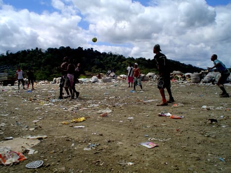 itabuna, bahia / brazil - september 22, 2011: waste pickers are seen playing football at the landfill in the city of itabuna.