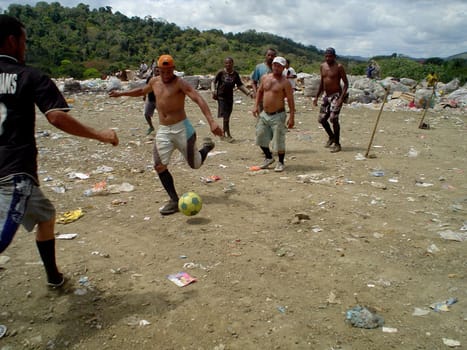itabuna, bahia / brazil - september 22, 2011: waste pickers are seen playing football at the landfill in the city of itabuna.