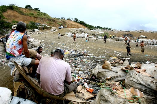itabuna, bahia / brazil - september 22, 2011: waste pickers watch their colleagues playing football at the sanitary landfill in the city of Itabuna.