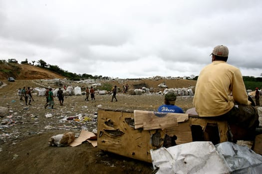 itabuna, bahia / brazil - september 22, 2011: waste pickers watch their colleagues playing football at the sanitary landfill in the city of Itabuna.