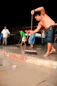 eunapolis, bahia / brazil - june 3, 2009: traders at a street market are seen removing rainwater that fell in the city of Eunapolis.